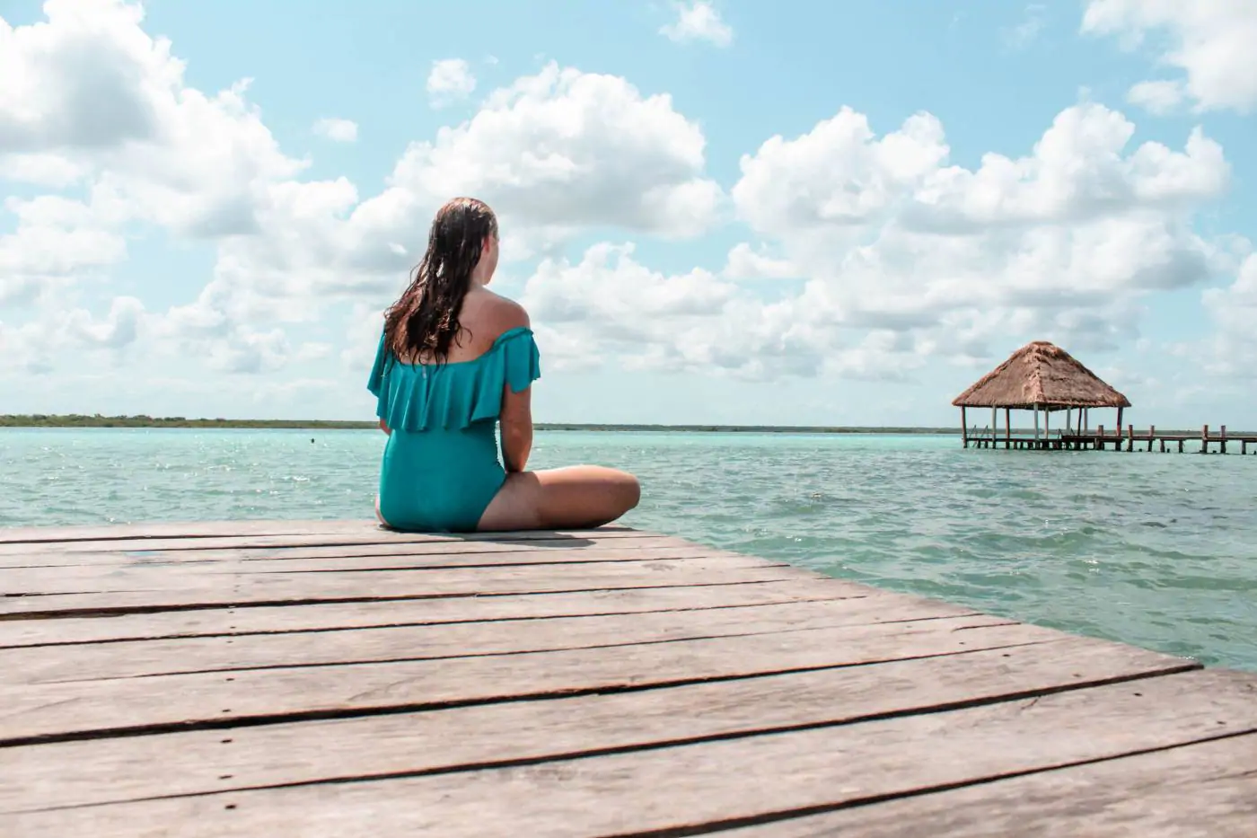 Sitting on the end of a dock overlooking the turquoise waters of Laguna Bacalar in Bacalar, Mexico.
