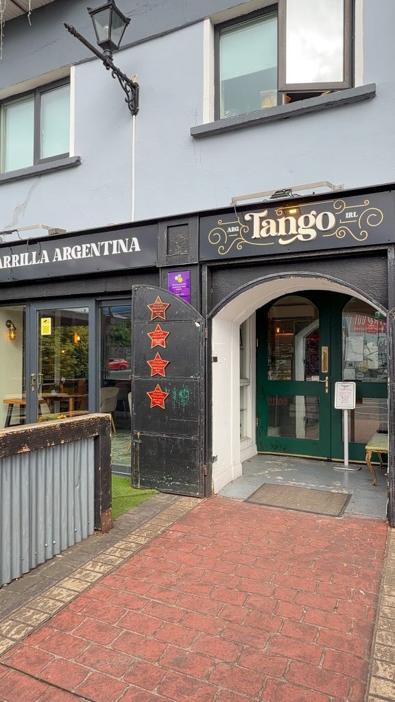 Gray building restaurant front that says Tango
