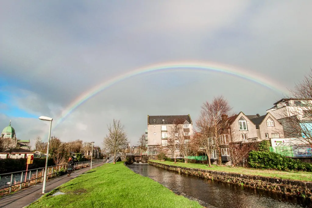 Canals of Galway, Ireland with a complete rainbow leading to Galway cathedral.