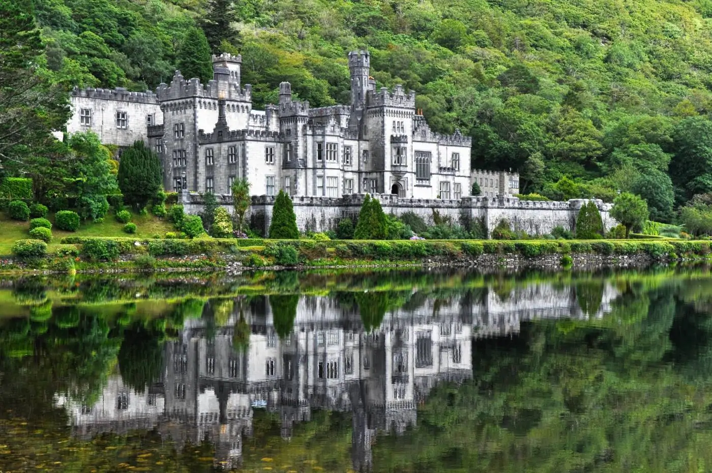 Kylemore Abbey set amongst lush green trees in Connemara.