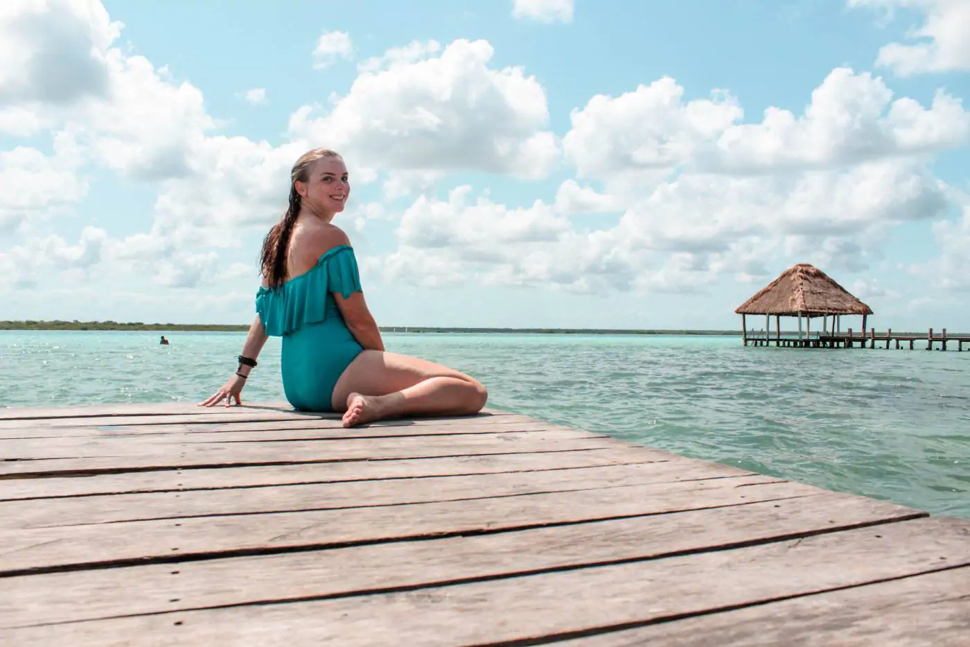 girl in bathing suit sitting on a dock