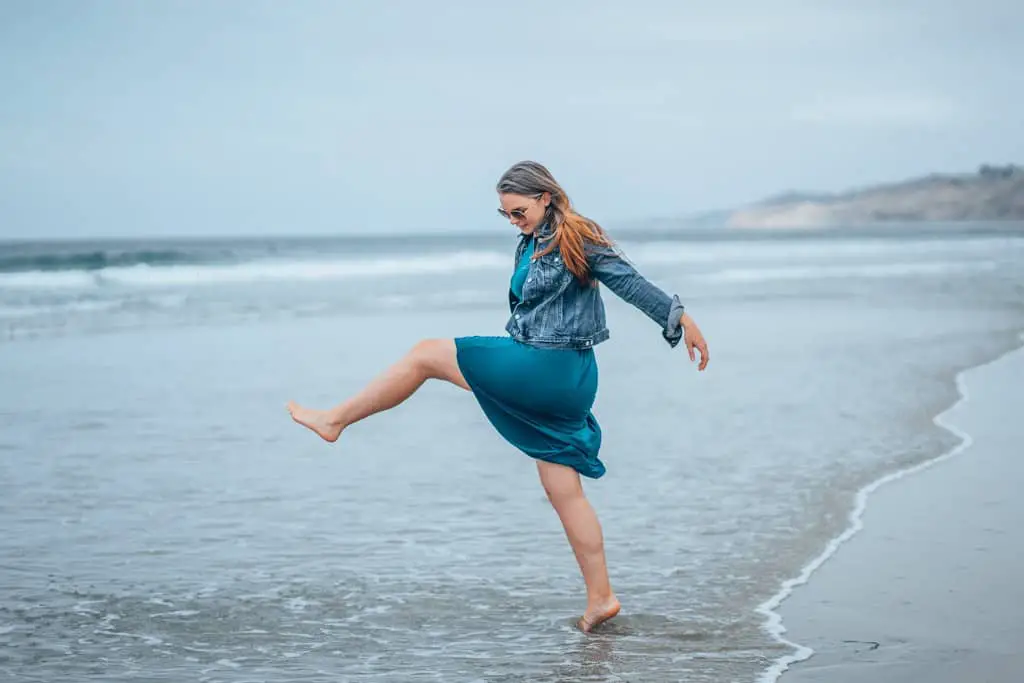 girl kicking leg on beach