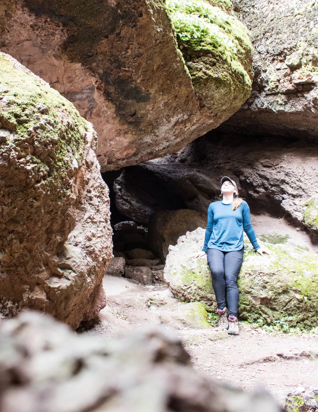 Me sitting on a rock looking up at the sky through the caves in Pinnacles National Park