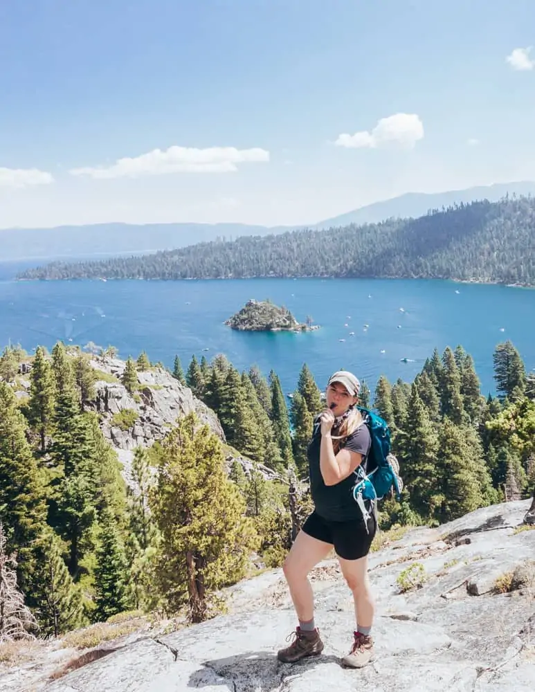 what to pack for a short hike: water. Me drinking water overlooking Emerald Bay in Lake Tahoe, California