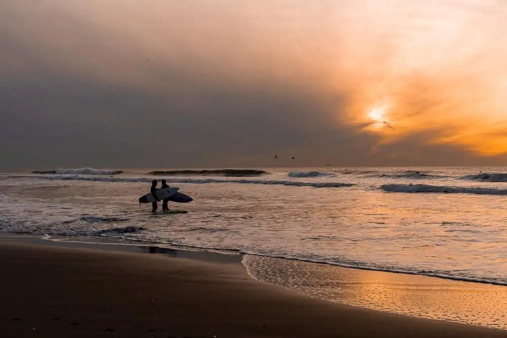 Best Beaches in San Francisco. Two surfers at sunset at Ocean Beach.