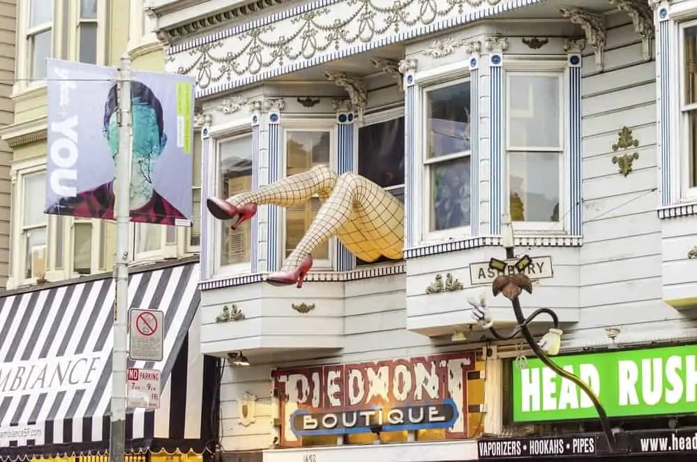 Haight Ashbury neighborhood in San Francisco, California, United States of America, a hippy area. View of a sculpture with large legs wearing fishnet stockings and red stiletto heel shoes out of a shop window.