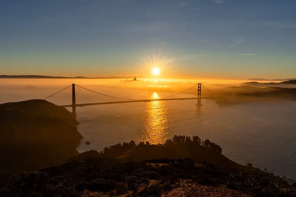 Hawk Hill Sunrise view of the Golden Gate Bridge and San Francisco skyline.