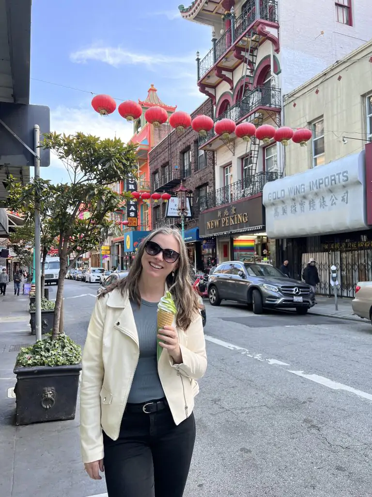 Wearing a white leather jacket, blue tank top, black jeans and eating a frozen yogurt on a street in Chinatown San Francisco.
