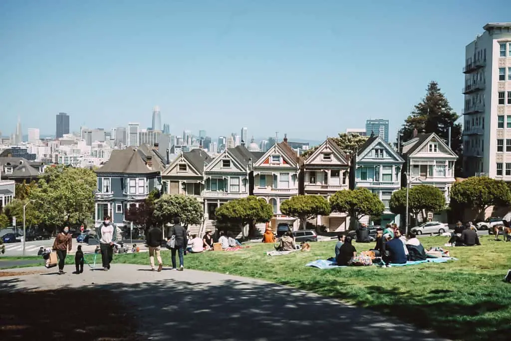 People having picnics at Alamo Square with the Painted Ladies.