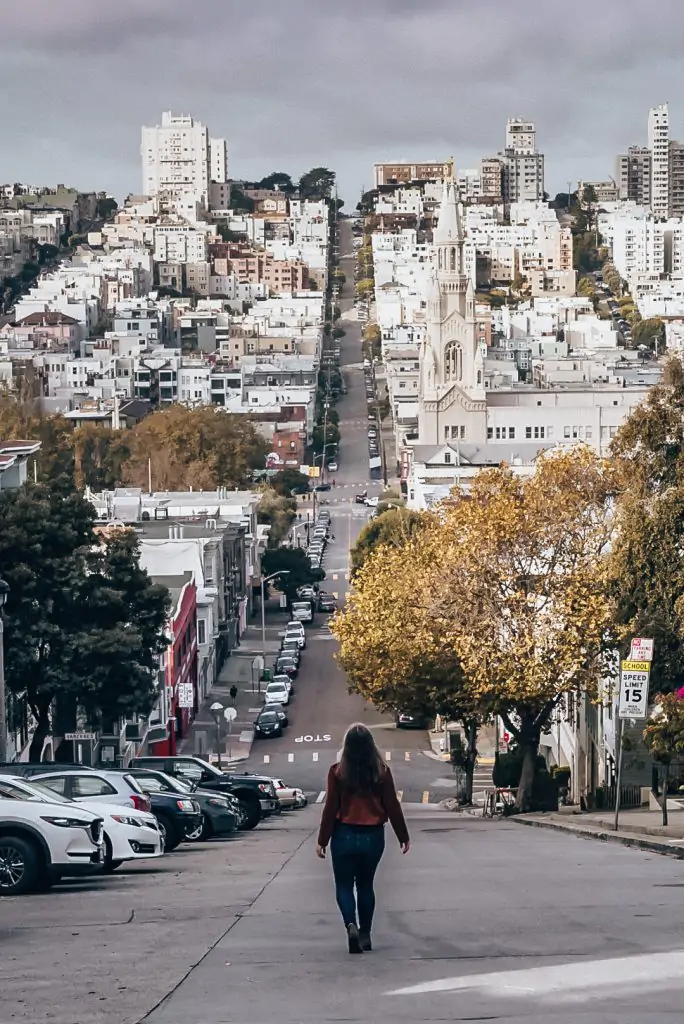 Me walking down Filbert Street with the spires of St. Peter and Paul's church below in North Beach, San Francisco
