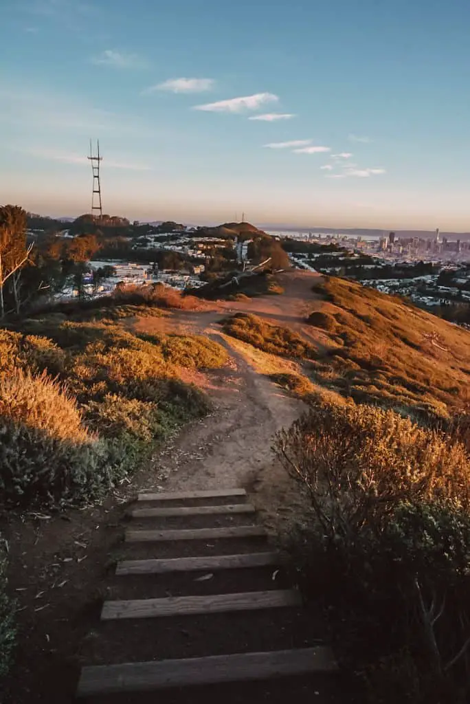 Pathway leading to the top of Mt. Davidson at sunrise with a view of Sutro Tower and Downtown San Francisco.