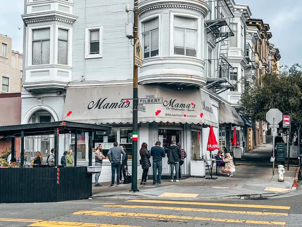 The front of Mama's on Washington Square with a line of people outside.