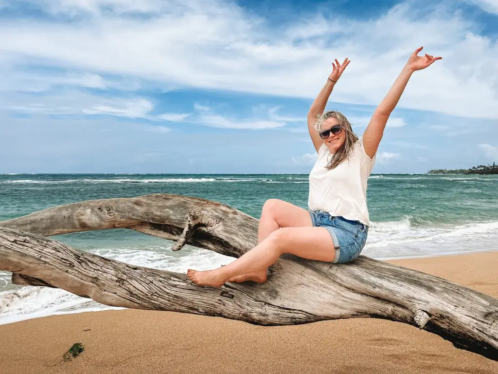 Things to do in Paia, Maui. Sitting on a tree branch on the beach in Paia Maui.