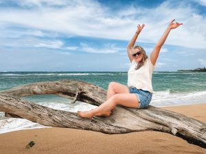 Things to do in Paia, Maui. Sitting on a tree branch on the beach in Paia Maui.