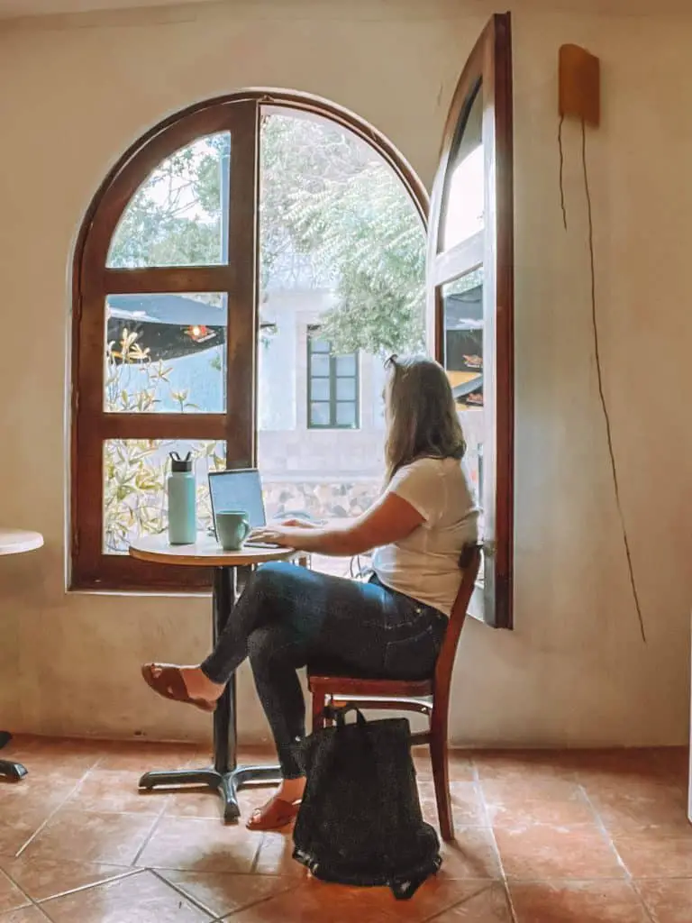 working on a computer in front of the window of Cafe Ole in Loreto, Mexico