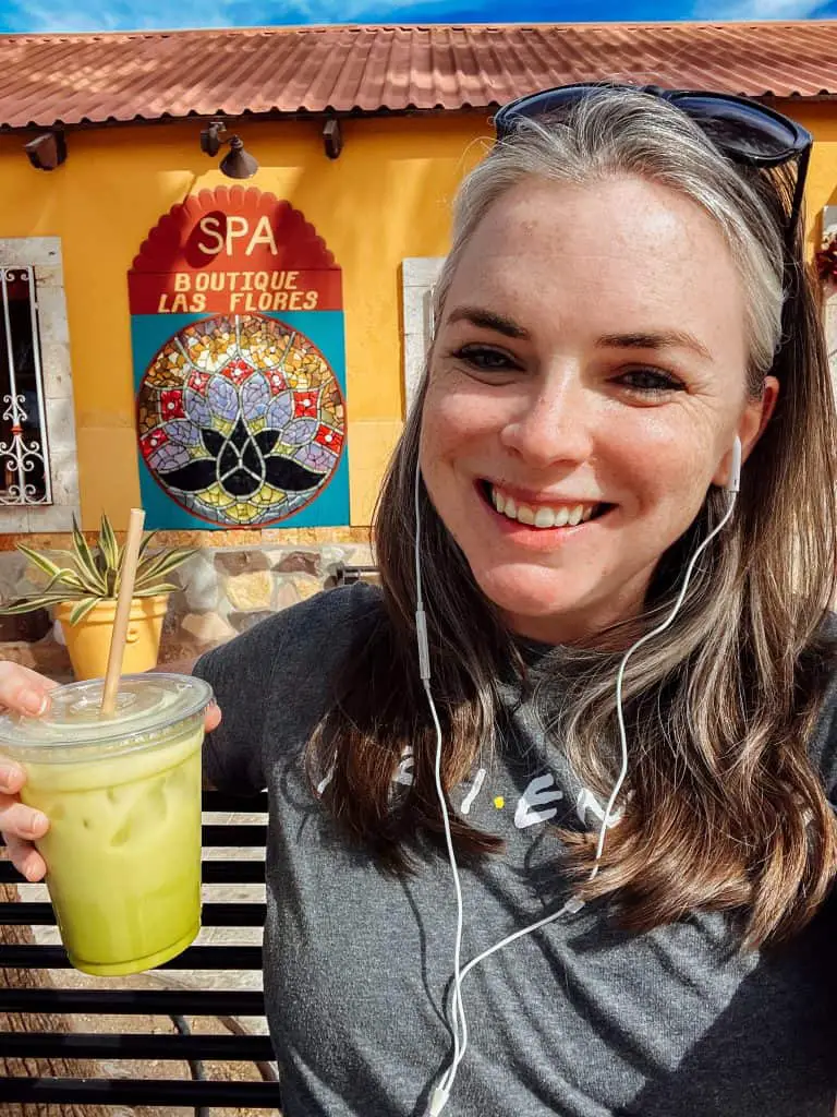 smiling with an iced matcha latte from La Route in Loreto, Mexico. 