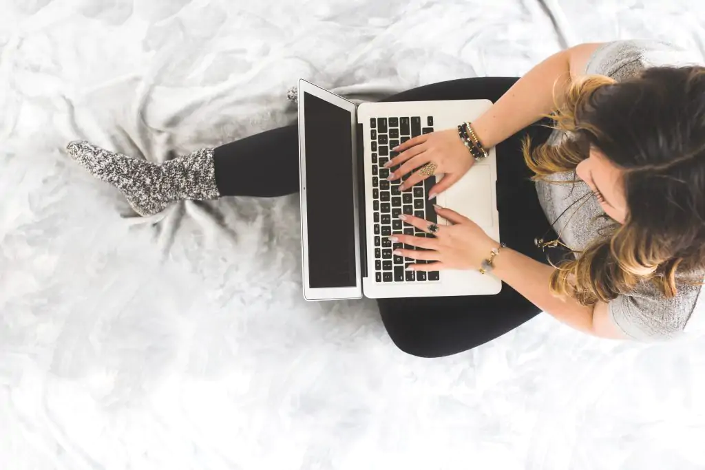 pinterest idea pins best practices. woman working on a laptop in bed