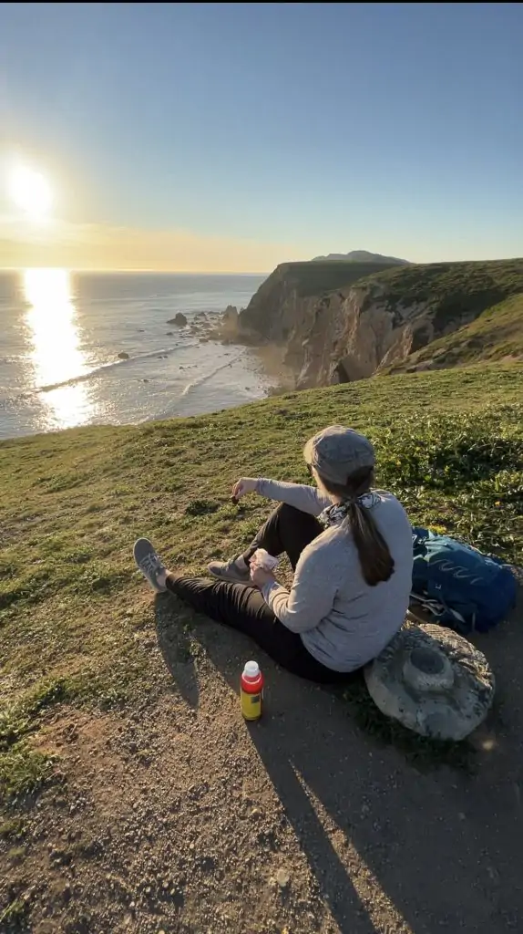 sitting at Chimney Rock at sunset eating snacks.