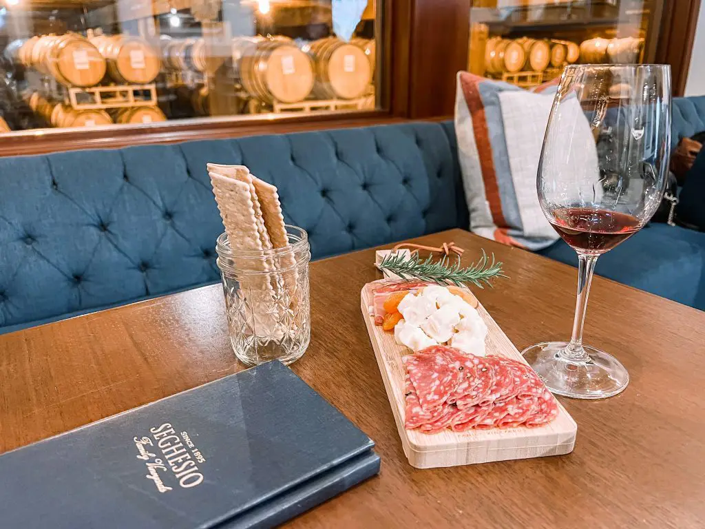 Seghesio family winery table with wine glass and charcuterie board.