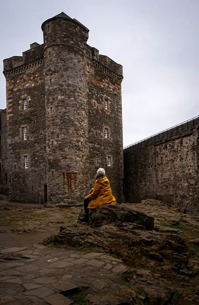 Me sitting on a rock in Blackness Castle in Scotland.