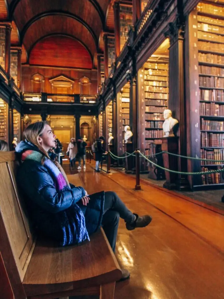Sitting in the Trinity College library on a bench.