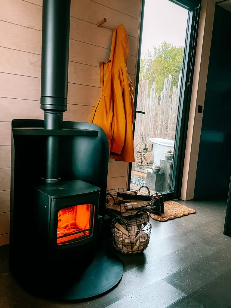 Fireplace and rain jacket hanging by the door in a cozy cabin.