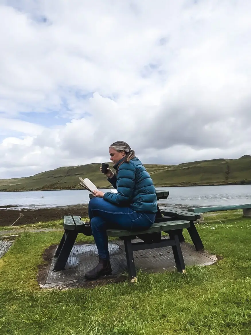 Me reading a book at a picnic table on the shores of a lake on the Isle of Skye, Scotland.