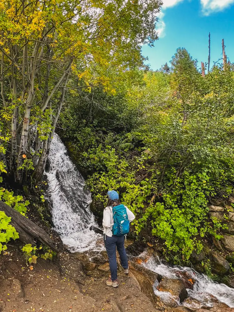 Standing at a base of a waterfall in Van Sickle Bi State Park in South Lake Tahoe, California.