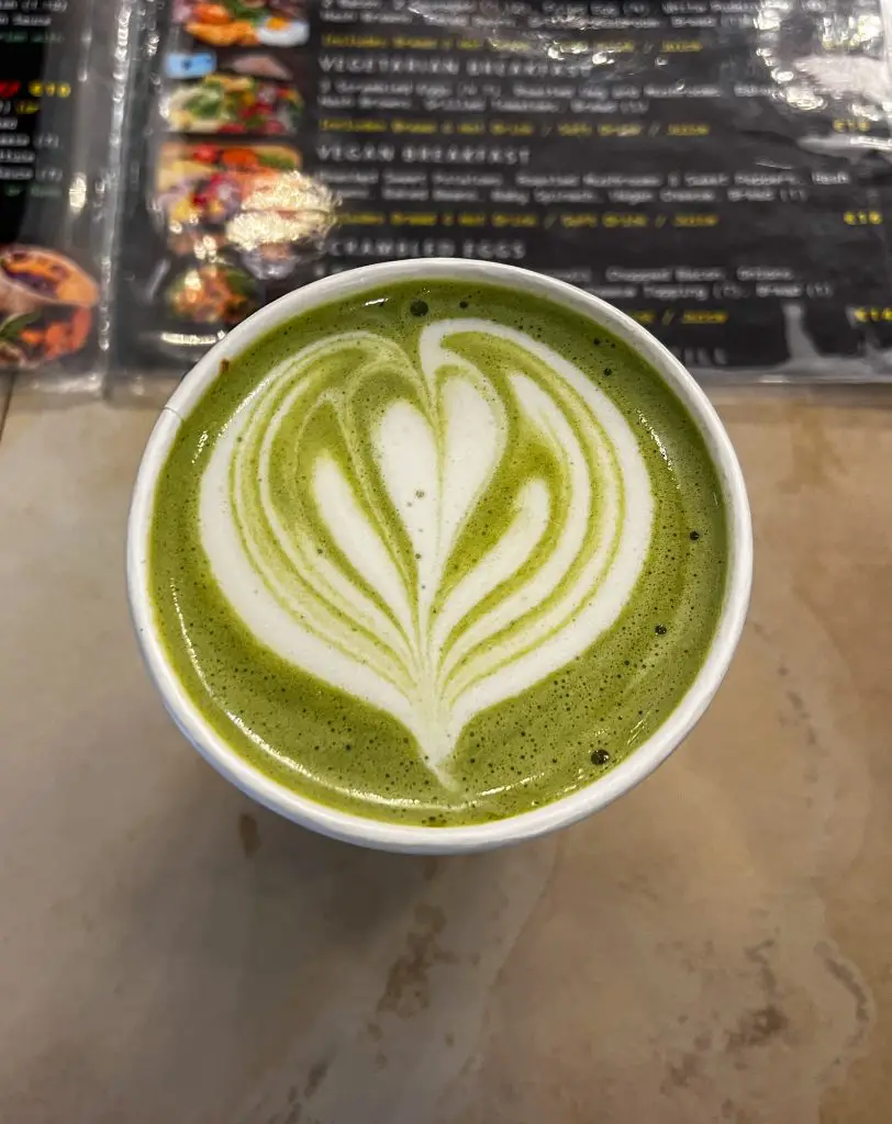Deep green matcha latte on a counter. 