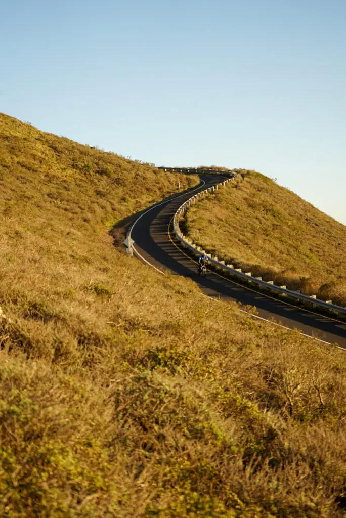 Window road surrounded by green hills.