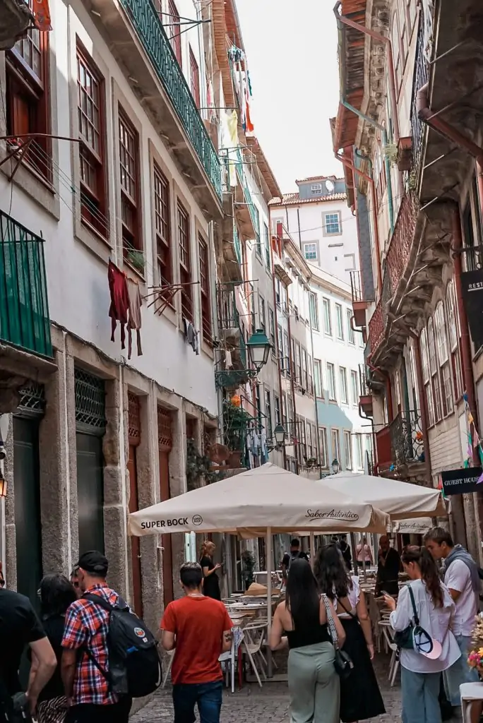 People walking down a narrow street in Porto, Portugal.