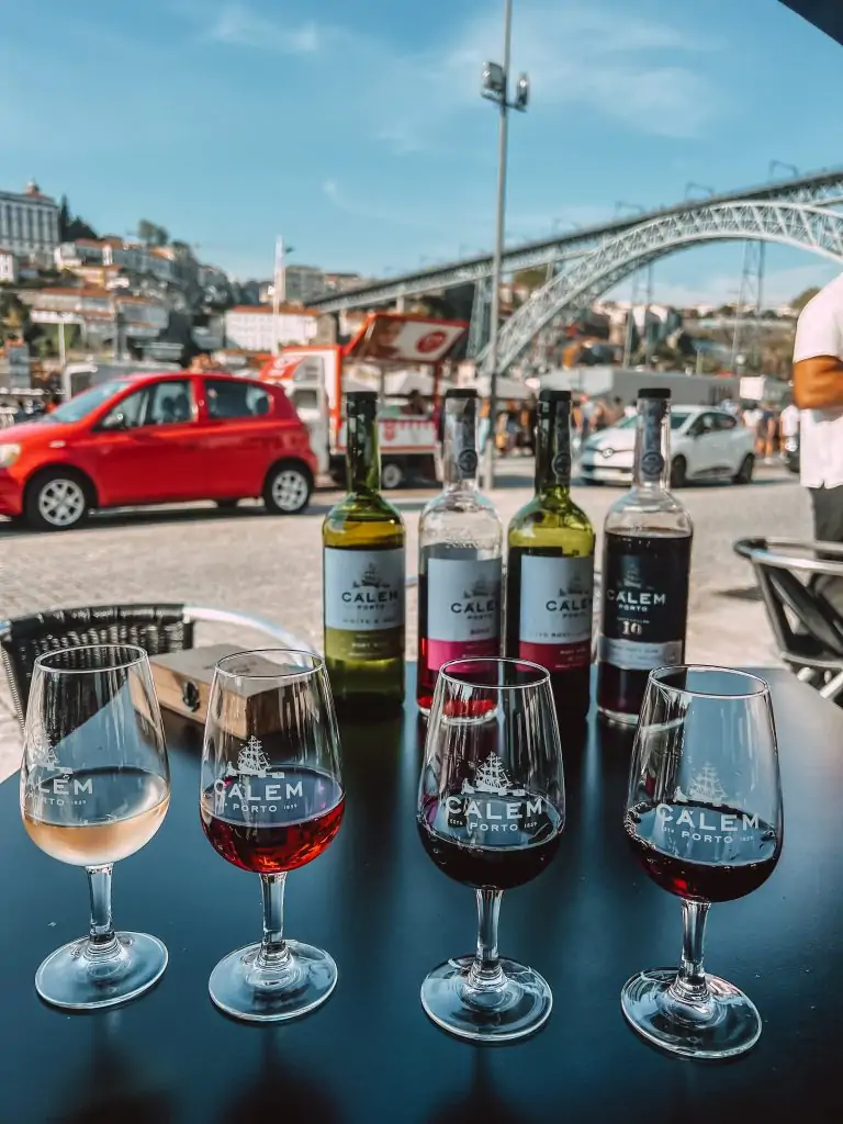 Bottles of port wine with the Ponte Luís I Bridge in the background in Porto, Portugal.