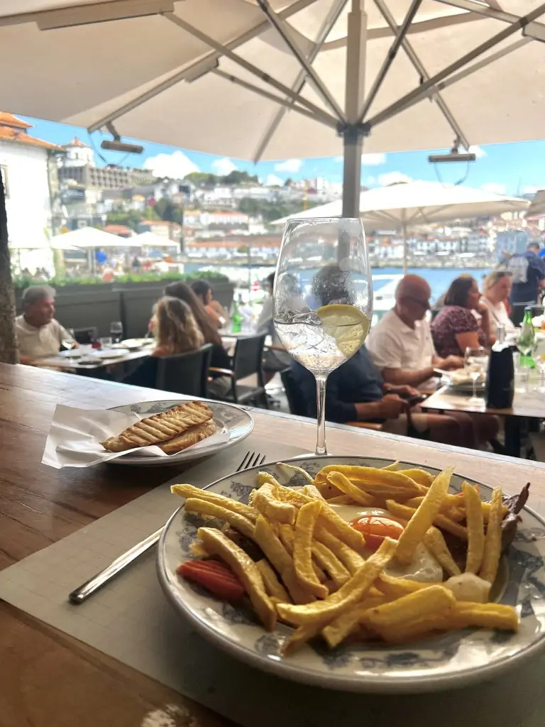 Plate of french fries with an egg overlooking a patio in Porto, Portugal.
