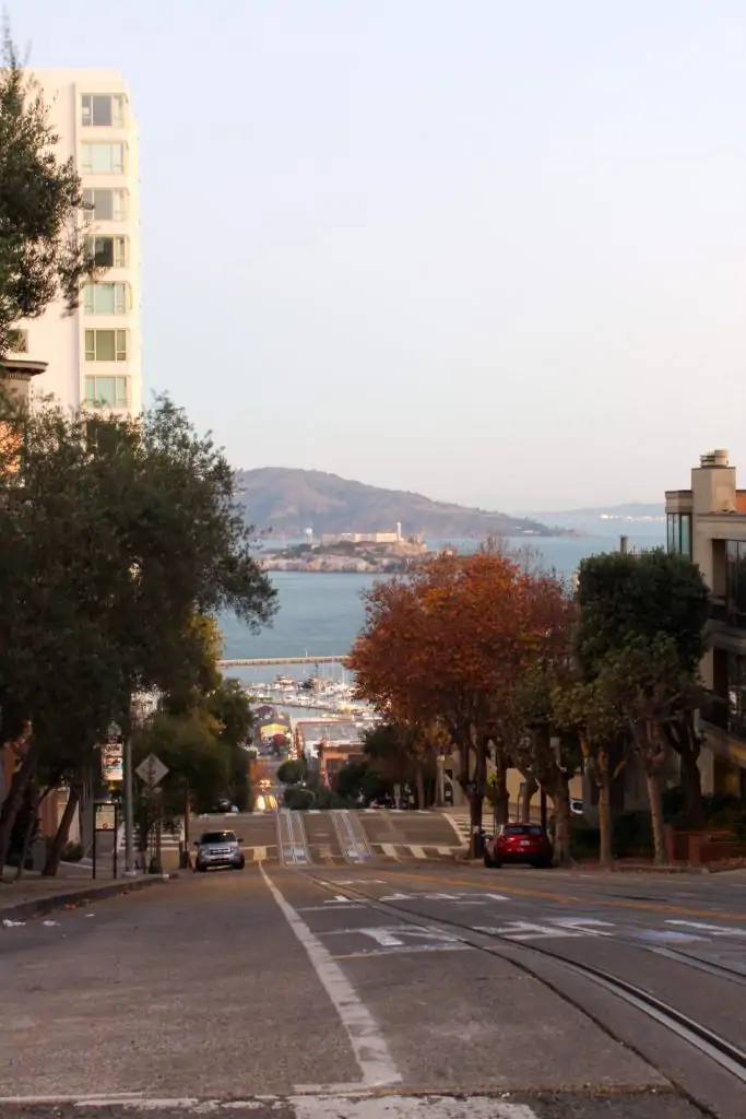 Steep hill in San Francisco with a view of Alcatraz Island.