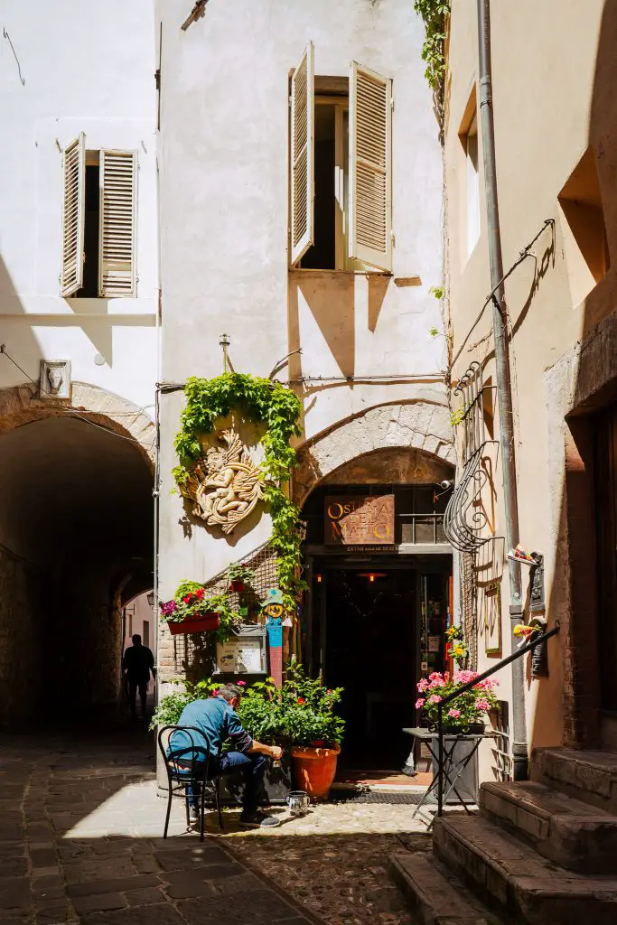 Man working in alley in Spoleto, Italy.