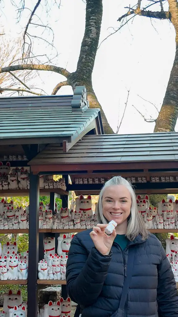 Me holding a Maneki-neko statue at Gotokuji Shrine in Tokyo, Japan.