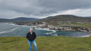 Katie standing on a cliff overlooking the White Cliffs of Ashleam, one of the best things to do on Achill Island in Ireland.
