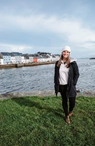 Katie in front of the colorful houses of the Long Walk in Galway, Ireland.