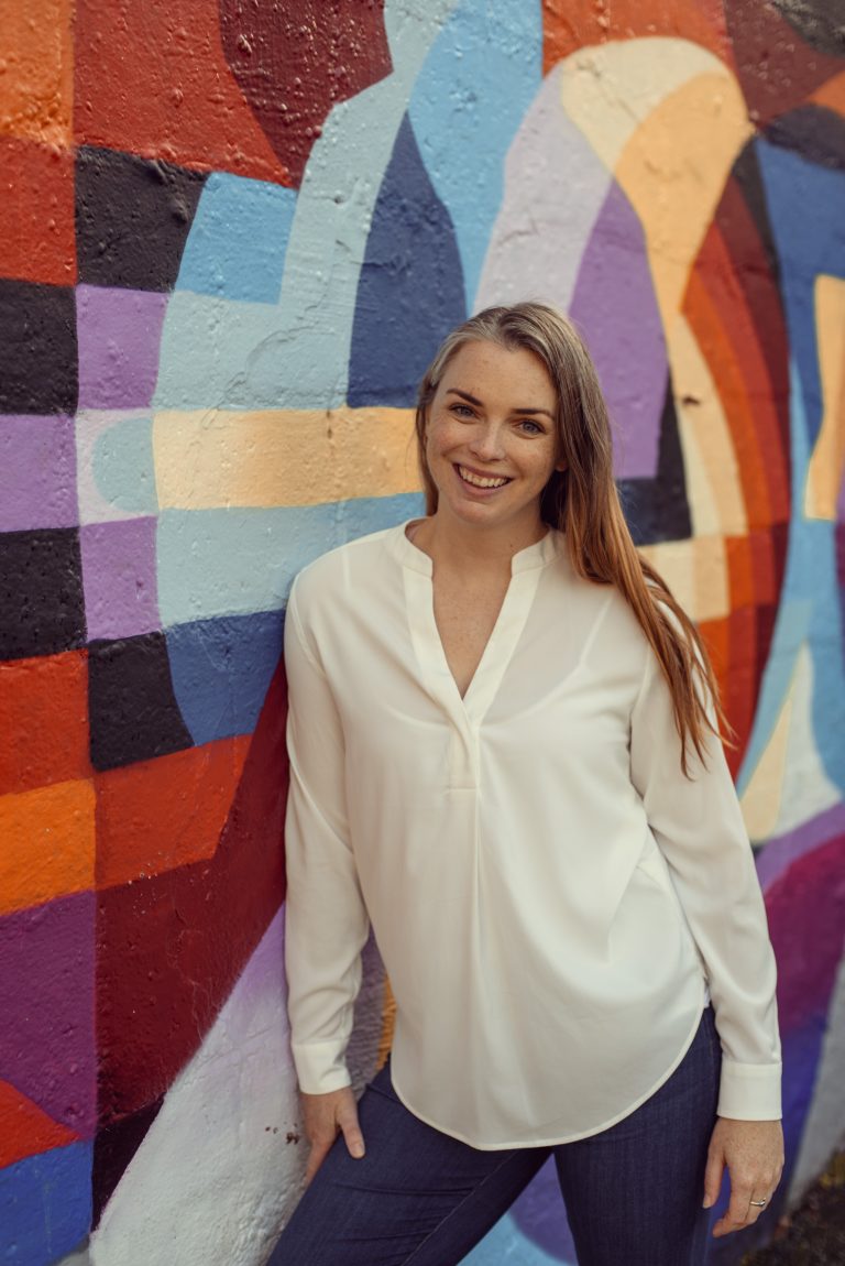 Katie in front of a colorful wall in Galway, Ireland