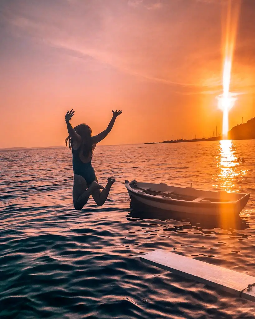 Katie jumping off diving board at sunset in Split, Croatia.