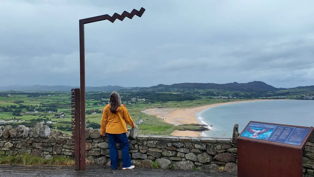Katie in front of Wild Atlantic Way sign in County Donegal, Ireland. How much does a trip to Ireland cost.