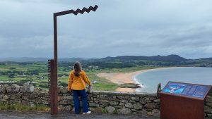 Katie in front of Wild Atlantic Way sign in County Donegal, Ireland. How much does a trip to Ireland cost.