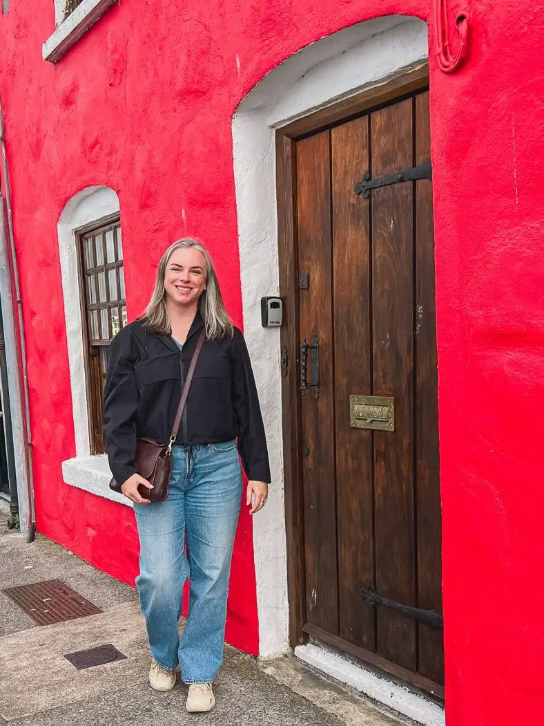 Katie in front of a red building in Galway, Ireland.