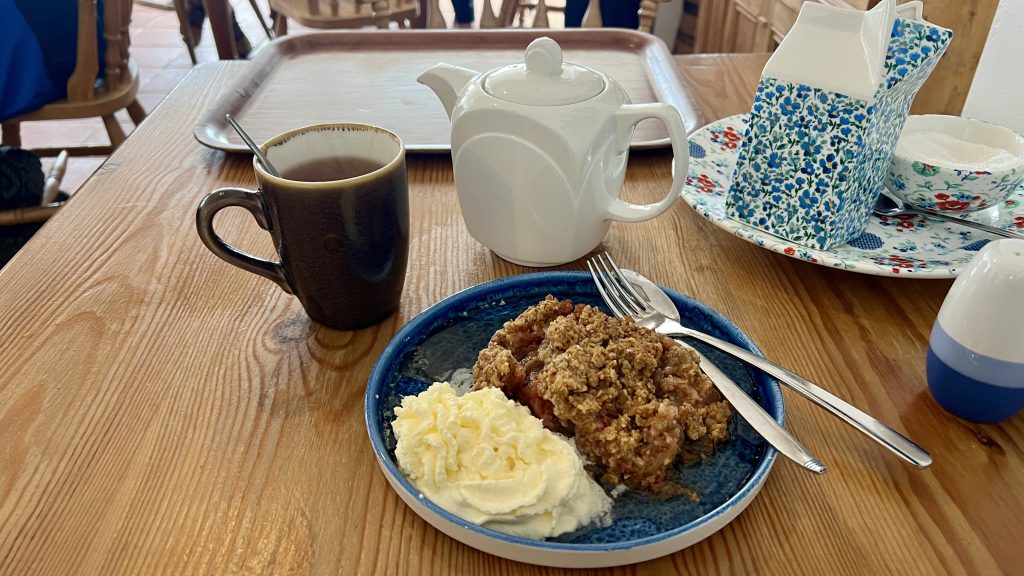 Berry crumble with ice cream and tea on a table.