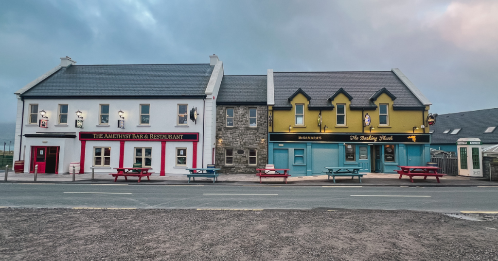 Two buildings, one restaurant and one pub across a street on a foggy evening on Achill Island, Ireland.