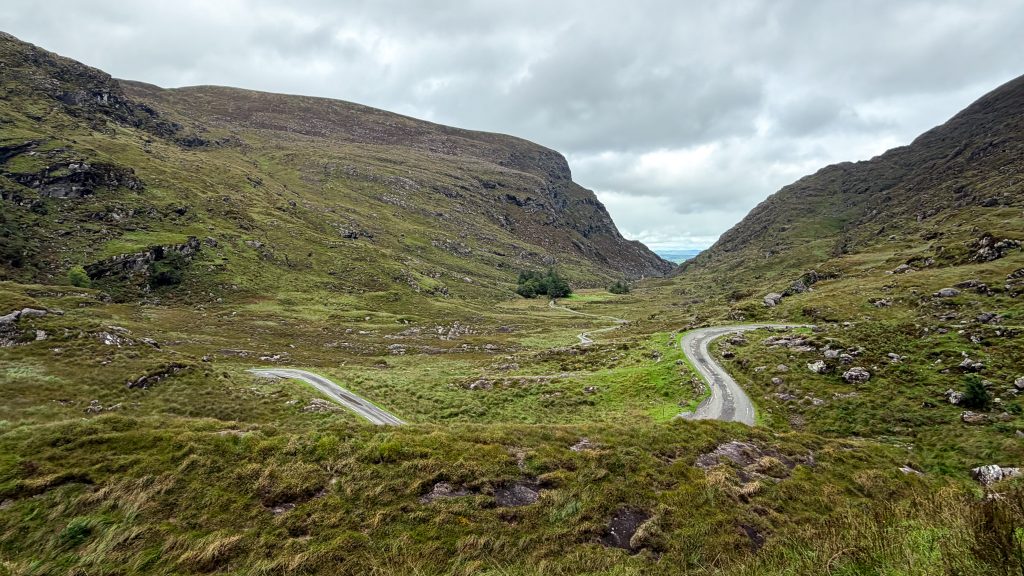 Switchbacks in a green mountainous valley in Ireland.