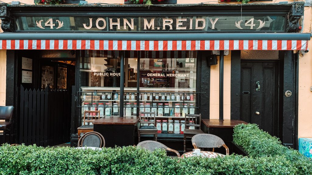 The front of John M Reidy's pub with tables in front of the window.